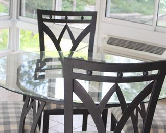 Glass top round table (45") with iron base and four chairs.