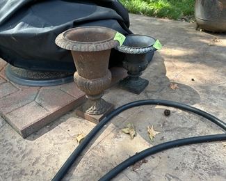 two smaller cast iron urns