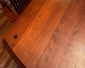 Detail of cherry wood table and diamond pattern wood inlay at the end of table