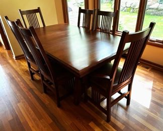 Arts and Crafts Amish  dining table and chairs, made of cherry wood, has two leaves inside and table pads.