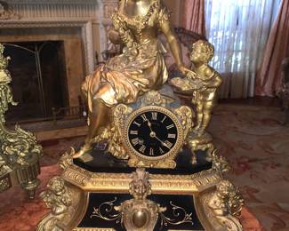 French gilt and black marble mantle clock with circular face.