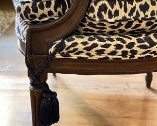 Antique Bergere chair upholstered in Schumacher leopard print fabric with tassel adornments on legs. Measures 26" W x 27"D. Photo 4 of 4. 