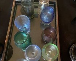 Set of colored liqueur glasses on tray.