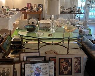 There are several items here:  the glass coffee table, the framed artwork pieces, decorative bowls, and a glass lamp.  