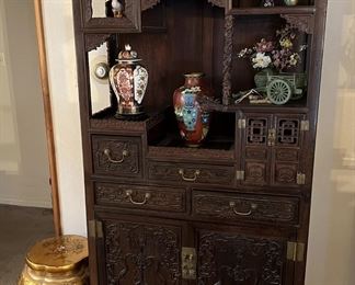Several decorative vases and figures are on this etagere display cabinet.