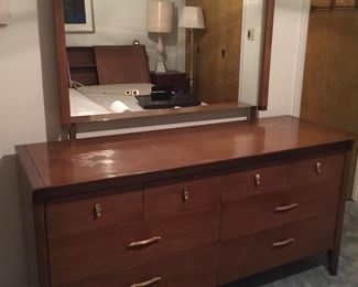 A Mid-Century Modern dresser by Drexel with mirror is in good condition with the exception of a spot on the top. The next image provides a better look at the flaw. 
