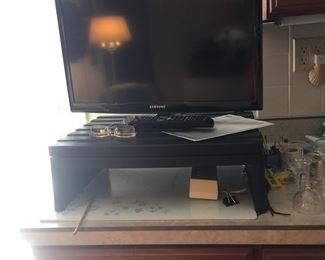 A flatscreen TV by Samsung comes with a remote and handy swivel stand. 