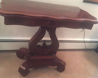 A card table with lyre-inspired solid base. 