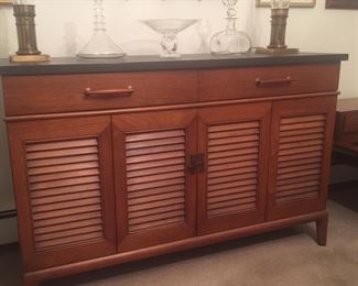 A Circa ‘60 Henredon Fine Furniture buffet has a black top. The twin drawers and louvered doors offer great spaces for table linens, china and more. 