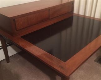 An end table with Mid-Century Modern flair has two drawers. A companion end table and coffee table are also available. 