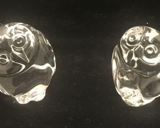 A set of owls with the one on the right holding a baby owl in its wings. 