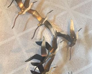 Seagulls fly off in this signed, artist-crafted metal wall hanging. 