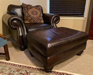 Large brown leather chair with brass nail head trim and a matching ottoman, both by Haverty's.  