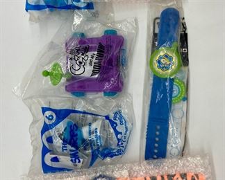Assorted packaged McDonald's Happy Meal toys including Madame Alexander, Smurfs, Cosmix, SpyBoy