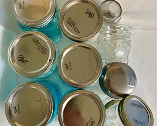 Assorted blue and clear Ball Mason jars with canning lids