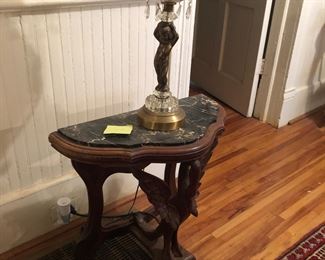 Half table with bird carving on front leg. Marble top. 25x12x23 tall