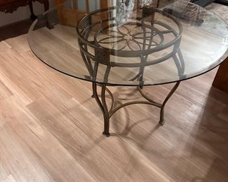 48-inch round glass top table with brass base.