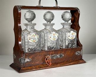 Cased Decanters Set | Three crystal decanters each with porcelain labels (brandy, rye, wine) nested in a wood carrying case with lock and key. -  l. 14 x w. 5.5 x h. 13 in (overall)