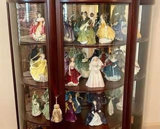 Curio of Hummels and Royal Doulton figurines.