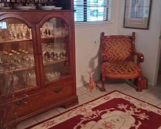 Antique clawfoot carved chair and lighted hutch