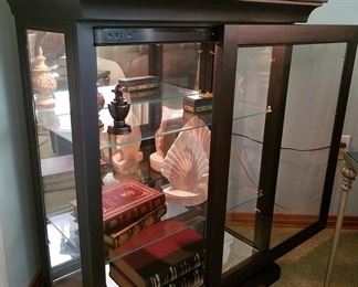 The curio cabinet front slides open