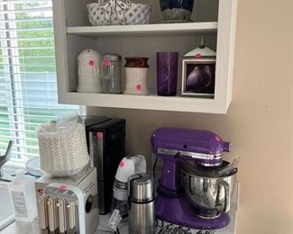 Purple Kitchen Aid mixer, silverware, hand mixer, coffee maker.