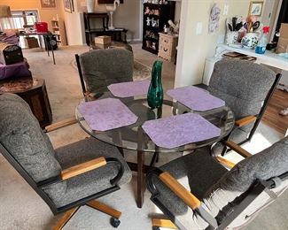 Glass top table with 4 swivel chairs.