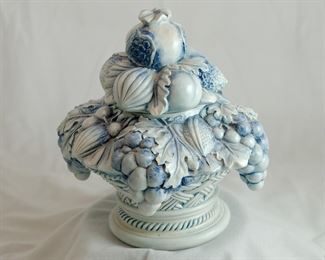 Italian pottery covered centerpiece, a fruit basket.  Minor damages to extremities -- tips of three leaves on lid flaked off, two tips of leaves on base flaked off.   Measures 8 1/2" tall and 8 1/2" across