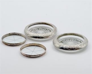 Two different pairs of sterling silver rimmed glass coasters, one with repoussé work