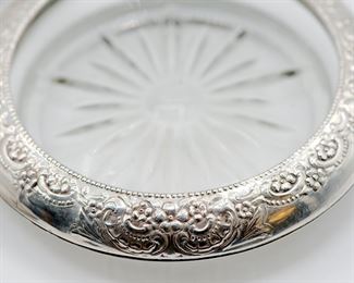 Detail of sterling silver rimmed glass coasters with repoussé work