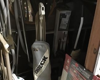 Whole closet under basement stairs of vacuums and old shop vac, one newer carpet cleaner