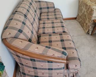 Standard 3 seat plaid sofa outlined by woodwork arms is in great condition.