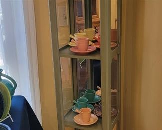 Corner display cabinet full of FIESTA stick handle demitasse cup and saucer sets.