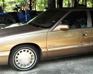 1998 Gold Cadillac Deville.  White leather interior