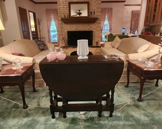 Matching sofas with matching cherrywood and tables and a matching oval coffee table and a drop leaf table.