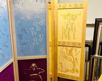 "Answered Prayers" folding screen of wood and metal panels.