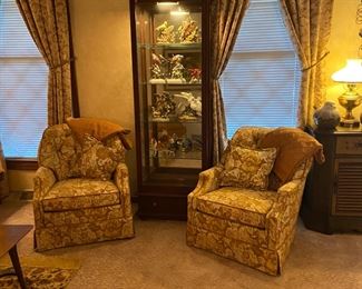 Beautiful lighted curio cabinet filled with ceramic bird figurines and two vintage floral chairs in excellent condition.
