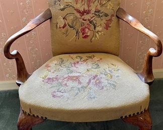 Antique needlepoint arm chair with wood frame and very unique arms.