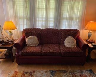 Comfortable couch nestled between a mahogany end tables and highlighted by gorgeous blue lamp pair.