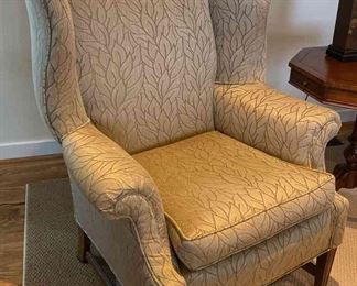 One of two upholstered wing back chairs