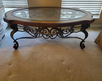 Oval glass-top with ornate metal filigree style accents and legs.  Heavy and sturdy.