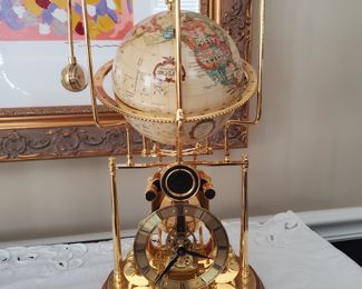 Cosmochronotrope clock - by Franklin Mint- Used. The Smithsonian Institute's Cosmochronotrope Globe Clock is a stunning display of brass and metal, featuring a skeleton design and a gold finish. Its quartz movement, powered by battery, ensures accurate timekeeping. 