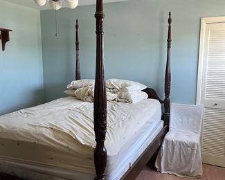 Three-piece bedroom suite: queen four-poster bed, dresser with mirror, and armoire