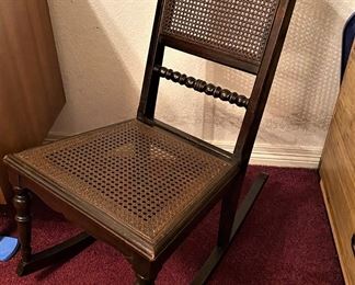 ANTIQUE CHILDS ROCKING CHAIR WITH CANE BOTTOM.