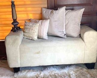 Cream Suede Bench With Rodeo Home Pillows, Faux Fur Rug, And Lamp