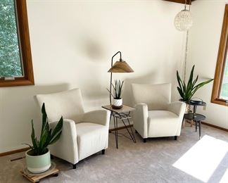 Upholstered chairs, mid century side table with lamp, houseplants 