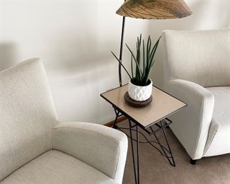 Upholstered chairs, mid century side table with lamp, houseplants 