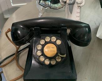 Collectible mid-century black rotary dial telephone and a sweet little Lladro  in the background.