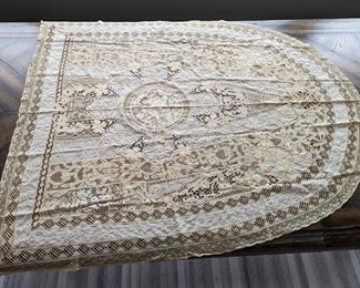 22.)  ca 1900 Handmade Mixed Lace Boudoir Throw.  Center medallion of handmade bobbin lace of a lady and gentleman in a garden.  This is surrounded by a larger medallion of fine batiste hand embroidered with satin stitch flowers.   Contains tape lace, Brussels bobbin lace , Cluny lace and fine embroidery.  46" wide x 57" long.  $375.00