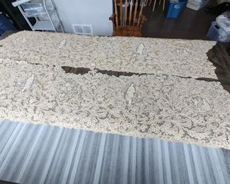 11.)  2 Panels Handmade Needle Lace Applied to Netting and Linen.  Extensive Figural work.  Panels are silk and linen.  Minor discoloration.  Previously attached to black lace.  1st panel:  97" longest point, 88" shortest point x                     2nd panel:  102" longest point, 98" shortest point.  $575.00